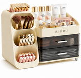 A cream-colored UFORU makeup organizer set shown filled with cosmetics, including brushes, lipsticks, compact powders, and small bottles, on a clean white background.